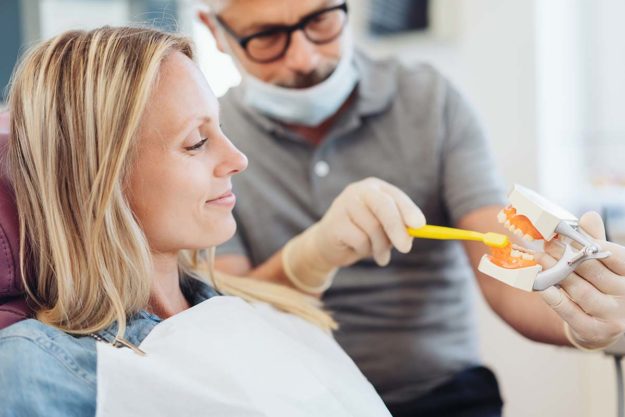 importance of dental hygiene (1) dentist teaching woman patient the importance of dental hygiene