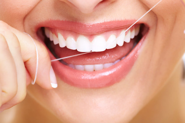 how to floss a woman uses floss after learning how to floss