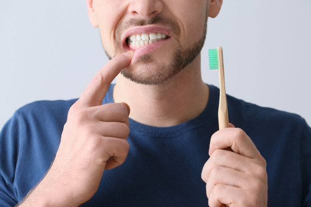 man suffers from symptoms of enamel decay