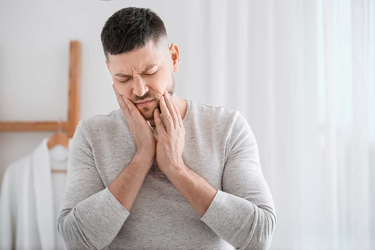 Common Symptoms of Tooth Decay Man exhibiting signs of painful tooth decay