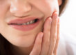 girl holding her mouth due to tooth nerve pain