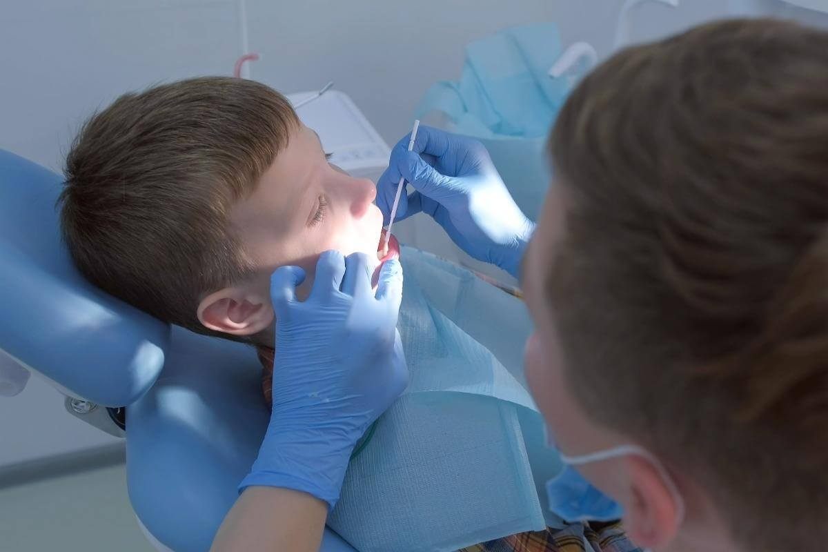 kid in dentist chair getting fluoride treatments for children