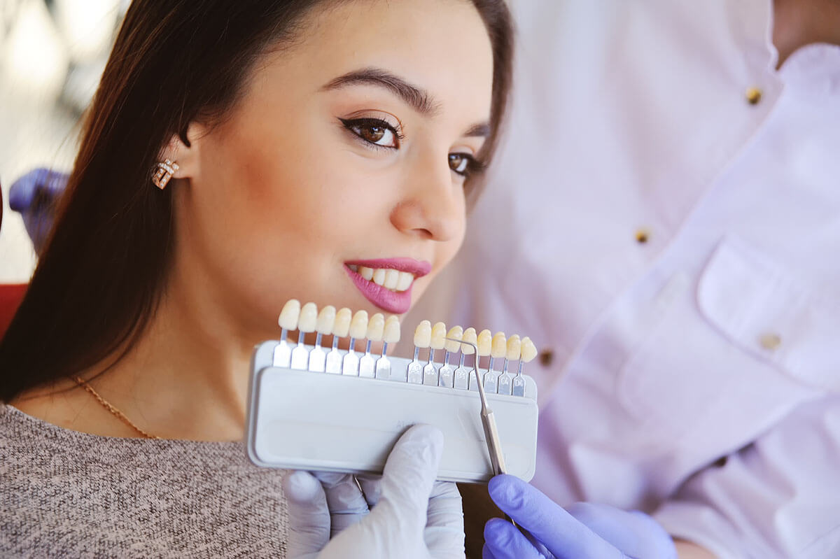 What Are Dental Veneers_ woman with brown hair in dentist office wondering what are dental veneers