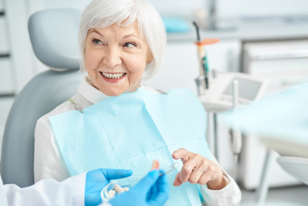 Can Periodontal Disease Cause My Teeth to Fall Out woman talks to her dentist about if periodontal disease causes teeth to fall out