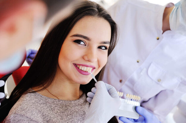 Are Dental Veneers Worth It_ patient smiles while discussing with her dentist why dental veneers are worth it
