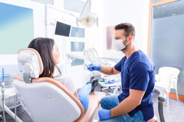 dentist talks to a patient about periodontitis best treatment