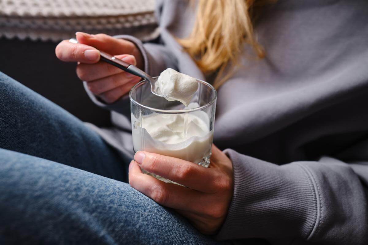 woman eats yogurt when learning about food to eat after wisdom teeth removal