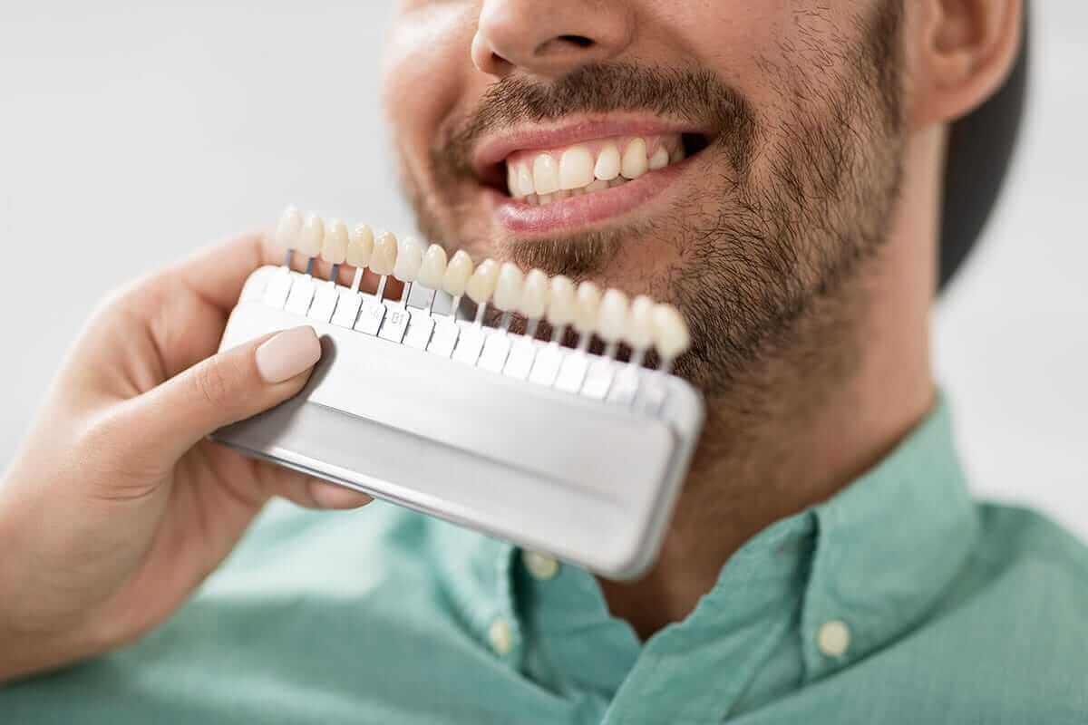 Where Can I Get Dental Veneers in Columbia, MD man matches dental veneers in columbia md to his teeth