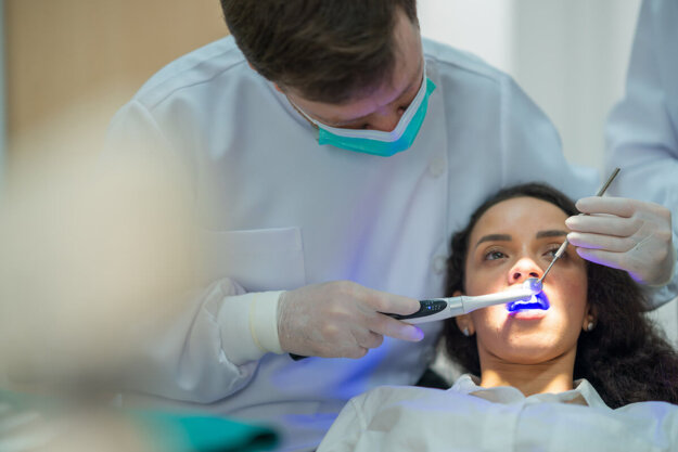 How Fluoride Helps Prevent Cavities Patient wondering how fluoride helps prevent cavities