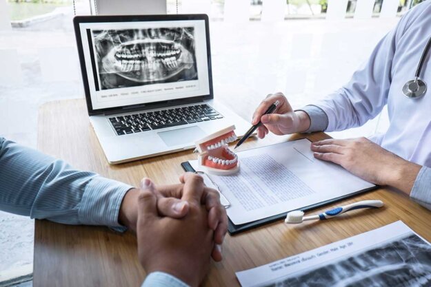 Which-Type-of-Dental-Implant-Would-Benefit-Me- A dentist discussing different types of dental implants to a patient